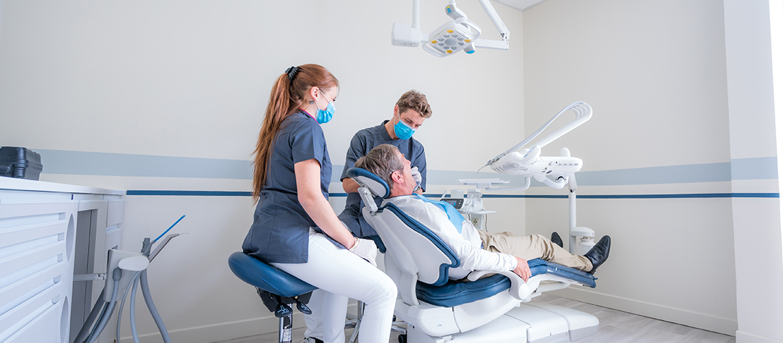 photo d'un dentiste et son assistante qui s'occupe d'un patient, clinique dentaire newport pantin